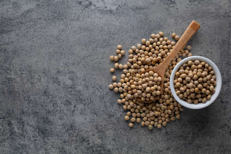 Soybean raw food nutrition in wooden spoon on a pileの写真素材