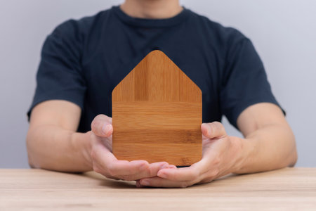 Home protection assurance insurance concept hand hold mini wooden houseの写真素材
