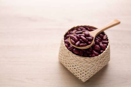 Organic red kidney bean in basket on wood table and wooden spoon. Protein nutrition ingredient for vegetarian.の写真素材