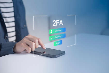 Businessman using smartphone and touching virtual screen for two-factor authentication for safety use of social networks and access to information privacyの写真素材