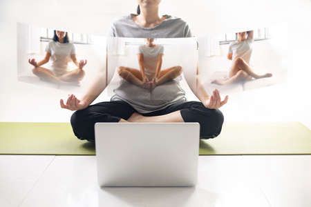 Women using laptop learning yoga at home via yoga online training. Woman studying yoga at home via videoconferencing. women start to practice meditation.の写真素材