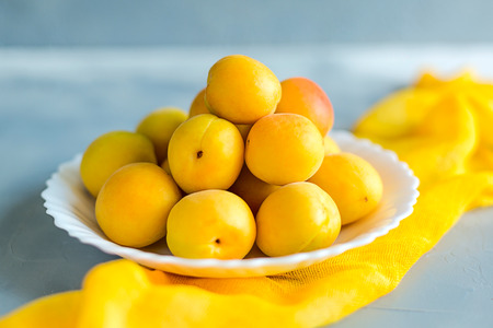 Some fresh and ripe apricots on the table colored in grey, decorated with napkins.の写真素材
