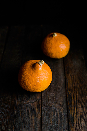 Red pumpkin on black wooden background, top viewの写真素材