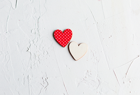 Top viw of two wooden decorative hearts on white concrete background. Love concept. St.Valentines day card.の写真素材