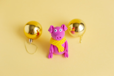 Hand made little purple plasticine pig on colorful paper background. Symbol of a chinese new year and chinese holiday concept.の写真素材