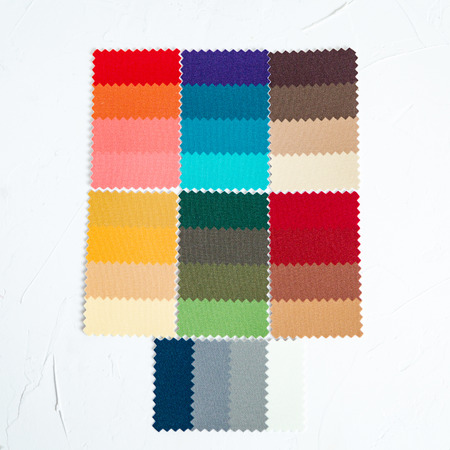 Top view of colorful felt swatches on white concrete table. Image maker of stylist instrument for color type determination.の写真素材