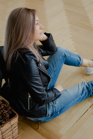 A blonde woman in a black leather jacket is sittingの写真素材