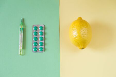 Some medication on two-color paper background. Top view of wo opposite medication. Home and science medication on yellow and green paper. Healthcare concept.の写真素材