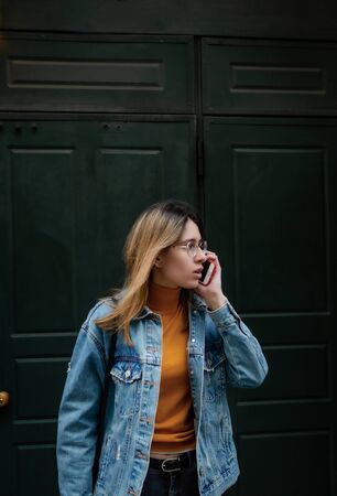 Blonde girl is walking on city streetの写真素材