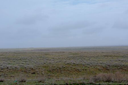 Landscape of wild Kalmyk steppe in a fog in spring early morning.の写真素材