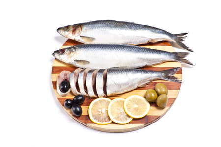 sliced herring on wooden plate isolated on whiteの写真素材