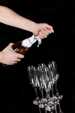 hands opening champagne bottle isolated on blackの写真素材