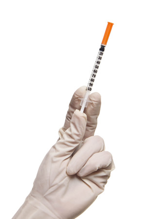 Hand holding syringe isolated on whiteの写真素材
