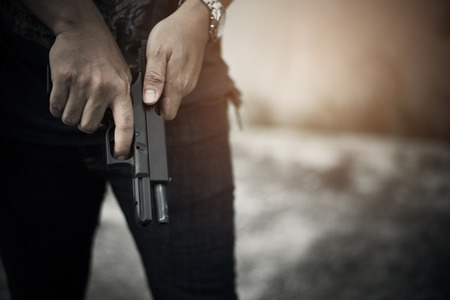 Robber holding gun for ready to murder steal moneys at abandoned building. Selective focus....