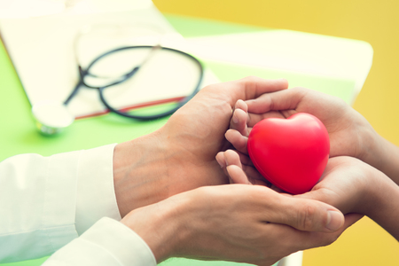 Hand of doctor give red heart to little patient children for recover from sickness. Hospital and Healthcare concept.の写真素材