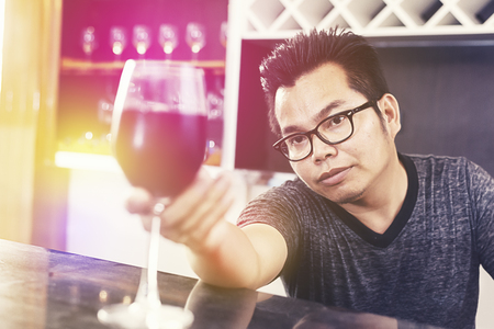Young man holding and need to drink alcohol wine. Holiday and Relax concept. Pub Bar and restaurant themeの写真素材