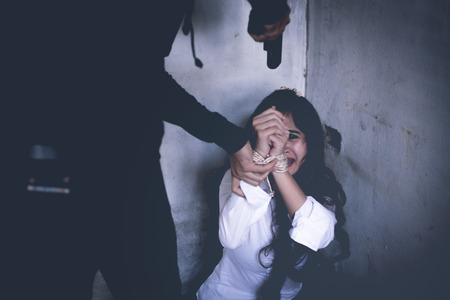 Robber force woman to take off her clothes in abandoned house with his gun. Raping and Criminal theme. Social issues and problem conceptの写真素材