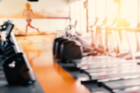 Blurry of Sports fitness workout gym with Bike and running machine or treadmill. Strength exercise and Cardio training concept. Sports center theme. Defocus sports equipment in background.の写真素材
