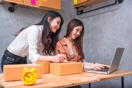 Two young Asian people startup small business entrepreneur SME distribution warehouse with parcel mail box. small  owner home office. Online marketing and product packaging and delivery serviceの写真素材