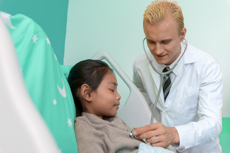 Doctor checking and analysis pulse of the heart from young patient in bed room ward. Healthcare and Hospital concept. Happiness life and insurance theme. Kids and Children theme.の写真素材