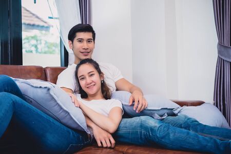 Asian young couples relaxing on sofa. Lovers and Couples concept. Honeymoon and Wedding theme. Interior and Dating theme.の写真素材
