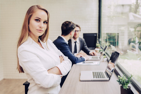 Business woman working with business team by laptop computer. Beauty and Technology concept. Smart lady and working woman theme. Office and happy life theme.の写真素材