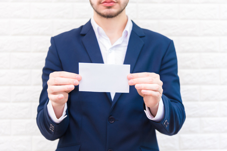 Business man showing white paper. Man  wearing blue suit and holding white blank card. Lifestyle and...