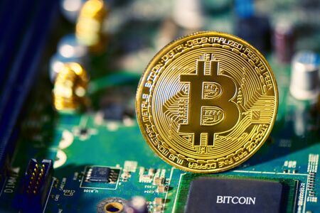 Bitcoin on electronic circuit board. Cryptography and Electronic money concept. Currency trading and...
