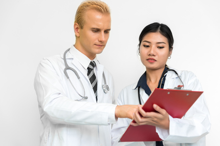 Doctor and assistant nurse checking patient laboratory test. Two hospital workers discussing on checking result list. Medical and Healthcare concept. People and Lifestyles theme.の写真素材
