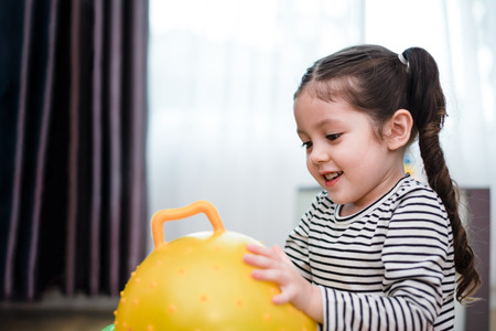 Little girl playing rubber ball in home. Education and Happiness lifestyle concept. Funny learning and Children development theme.の写真素材