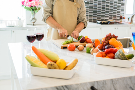 Man cooking and slicing vegetable in the kitchen. People and lifestyles concept. Food and drink theme.の写真素材