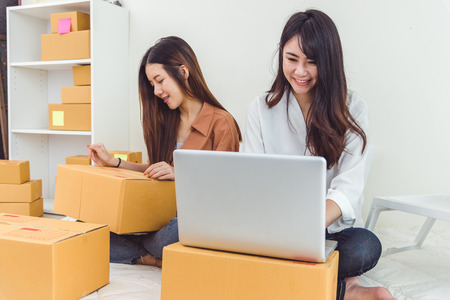 Young Asian woman startup small business entrepreneur SME distribution warehouse with parcel mail...