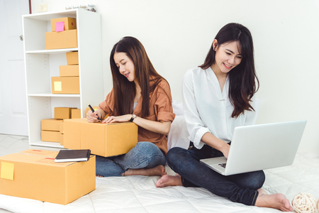 Young Asian woman startup small business entrepreneur SME distribution warehouse with parcel mail box. Owner home office concept. Online marketing and product packaging and delivery service.の写真素材