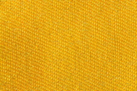 Yellow gold canvas fabric texture background. Textile and decoration concept. Wallpaper and interior designの写真素材