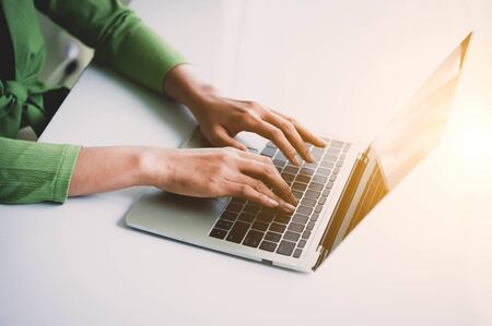 Closeup of woman hand working at home office and typing on keyboard. Business and technology theme. People lifestyles and Office occupation concept. Accounting and Computer freelance programming themeの写真素材