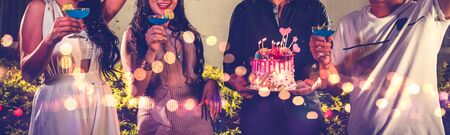 Closeup lower body friends group having outdoor birthday party at night club with birthday cake. Event and anniversary concept. People lifestyles and friendship forever in night club banner backgroundの写真素材