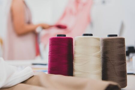 Closeup of colorful thread with fashion designer background in workshop studio. Stylish fashionista...