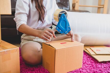 Closeup of Asian business woman hand startup small business entrepreneur SME distribution warehouse with parcel mail box. small owner home office. Online marketing and product packaging and deliveryの写真素材