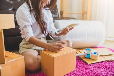 Asian business woman startup small business entrepreneur SME distribution warehouse with parcel mail box. small owner home office. Online marketing and product packaging and delivery service conceptの写真素材