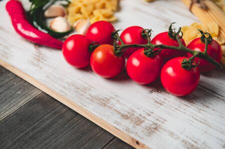 Tasty appetizing italian spaghetti pasta ingredients for kitchen cuisine with tomato, cheese parmesan, olive oil, fettuccine and basil on wooden brown table. Food Italian recipe homemade. Top viewの写真素材