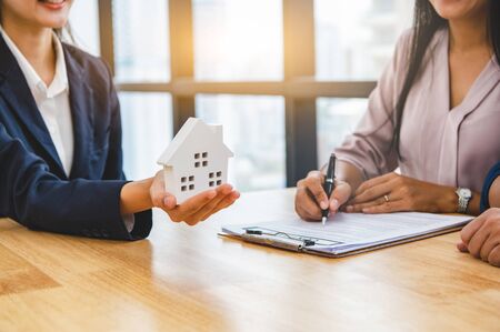 Real estate broker agent offer private home to customer before sign contract agreement documents for rental house property. Ownership realty purchase. Mortgage loan approval concept. Money investmentの写真素材