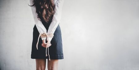 Back view of woman hostage in the abandoned house. Business woman tied and kidnapped from robber for abuse and sexual in abandoned house. Ransom and criminal. Copy space and blank for text on rightの写真素材