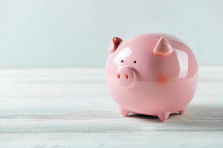 Pink Piggy bank on white wood floor. Financial and money savings concept. Copy spaceの写真素材