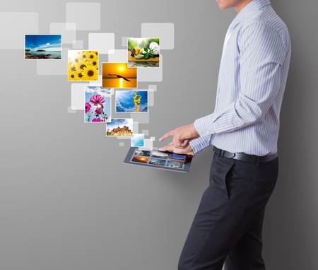 business man shows touch screen tablet with streaming imagesの写真素材