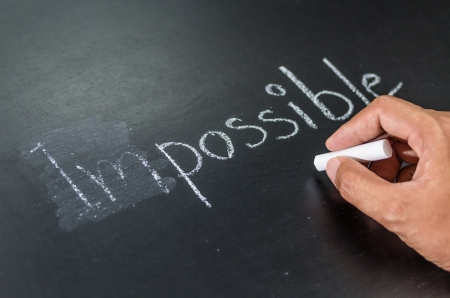 Changing impossible into possible on a chalkboardの写真素材