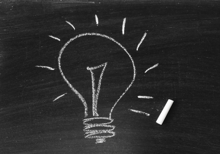 Drawing of a bulb idea on black boardの写真素材
