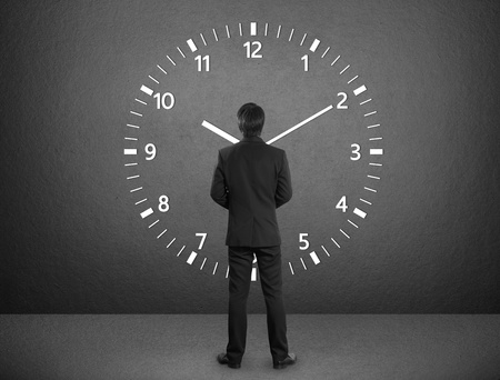 Business man standing and timesの写真素材