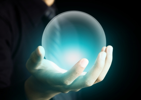 Hand holding a glowing crystal ballの写真素材