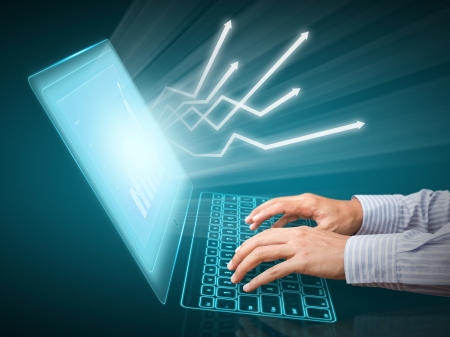 Analyzing financial data and charts on computer screenの写真素材