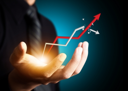 Hand holding a rising arrow, representing business growth の写真素材
